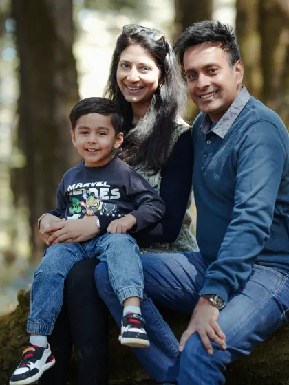 A beautiful, classic family portrait taken in the woods, showcasing their happy smiles and the natural beauty of Shimla.