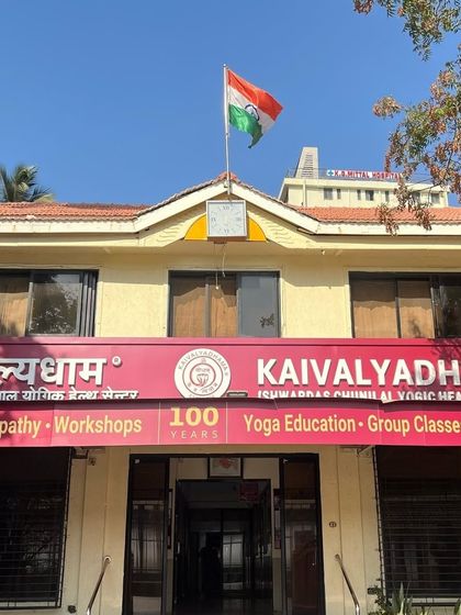 The facade of my Mumbai campus, Kaivalyadhama, with the Indian flag flying proudly. The "100 Years" banner signifies a century of unwavering dedication to yoga education, research, and practice.