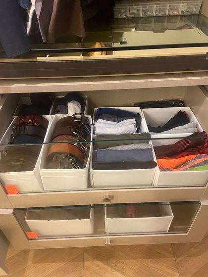 We use simple, effective bins to categorize items within a drawer, such as belts and folded t-shirts.