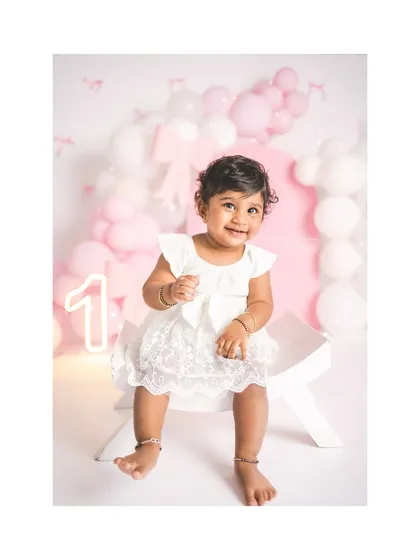 A sweet and simple first birthday portrait. The pink bow theme is classic and beautiful, letting her adorable expression shine.