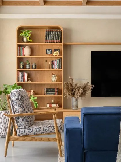 Another angle of the TV and curio unit in 'Cover me in Sunshine', highlighting the rounded corners of the bookshelf and the clean lines of the floating shelf.