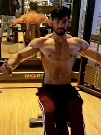 Performing a seated cable fly, an excellent exercise for isolating and building the chest muscles.
