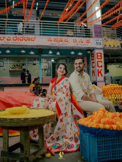 A posed portrait of the couple seated amidst the flower stalls. I help couples find comfortable and natural poses that fit the environment, resulting in relaxed and beautiful photos.