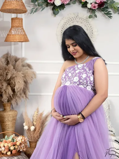 A quiet and serene moment, as she looks down at her bump with love. The soft lighting enhances the peaceful mood.