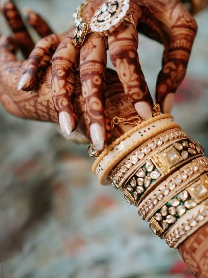 A detailed shot of the bride's hands, showcasing the intricate mehendi alongside her beautiful rings and bangles.