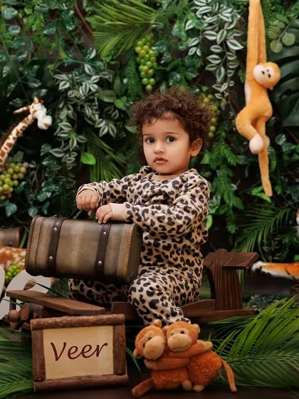 A personalized jungle theme shoot, with a sign for "Veer" among the lush greenery and friendly animal props.