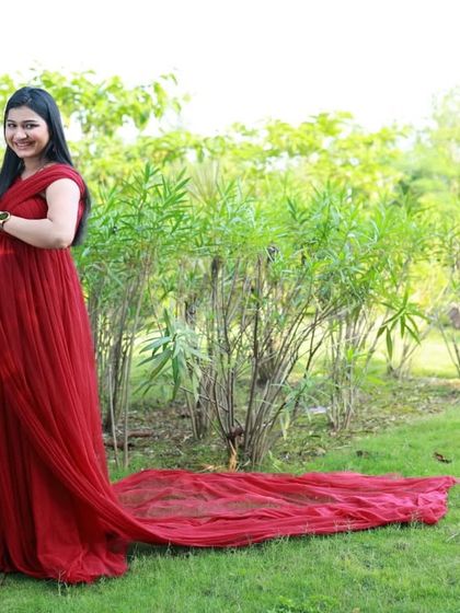 The long trail of this wine-colored A-line gown is on full display in this side-profile shot. It's a simple, elegant, and comfortable option for any mom-to-be.