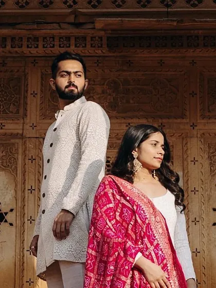 A regal pose against the intricate architecture of Jaisalmer. The traditional outfits are complemented by classic, clean makeup and softly styled hair, creating a timeless pre-wedding portrait.