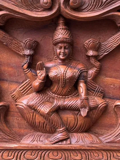 A close-up of Goddess Gajalakshmi from a 36-inch panel. The fine details of her expression and ornaments are highlighted by the rich, dark polish, creating a sense of divine serenity.