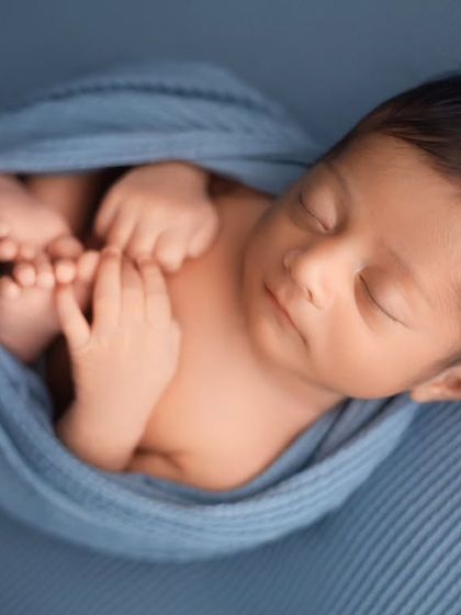 This classic swaddle technique, known as the 'potato sack' pose, is perfectly safe and keeps babies very content. It's ideal for showing off their tiny hands and feet.