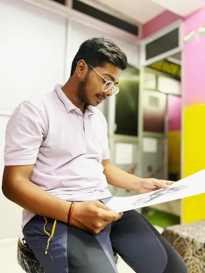 Me looking at my completed Radha Krishna sketch. The Hindi couplet speaks of a love that transcends lifetimes, which is what I tried to capture in this piece.