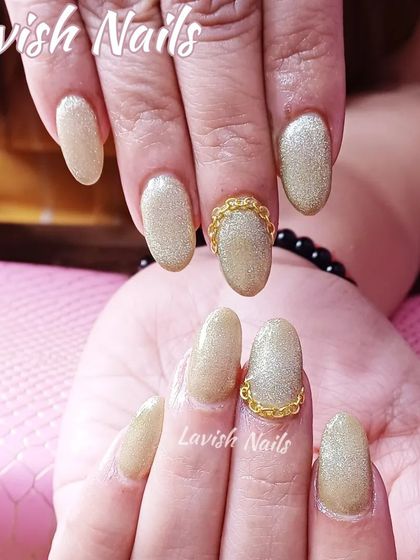 Elegant champagne glitter nails with a unique 3D gold chain detail at the cuticle.