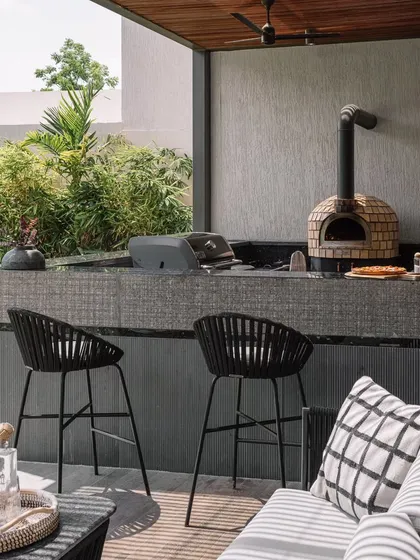 Outdoor living is central to our design approach. At our GAIA project in Chennai, we created this functional and stylish outdoor bar and kitchen, complete with a pizza oven, to extend the home's living space and encourage moments of connection in a natural setting.