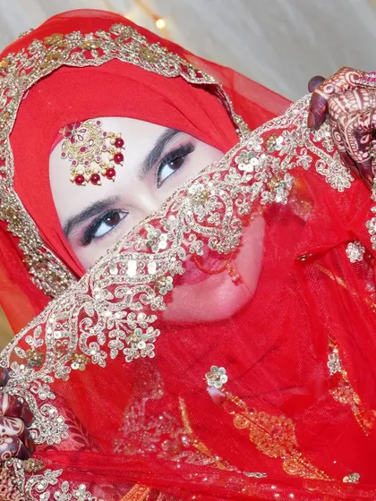 A portrait of a beautiful Muslim bride in her traditional red wedding attire. We ensure we capture the cultural richness and personal details of every wedding we cover.