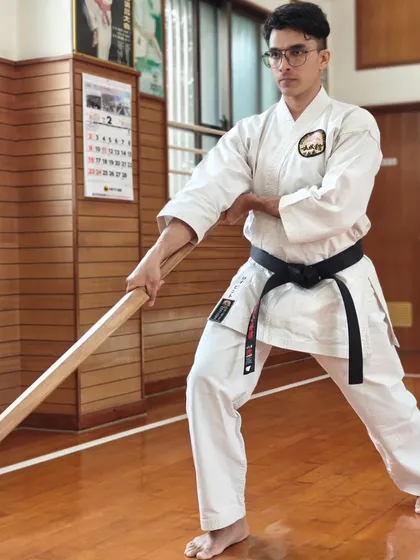 The focus and form of a student practicing advanced Bojutsu techniques in the very dojo where these arts were refined.