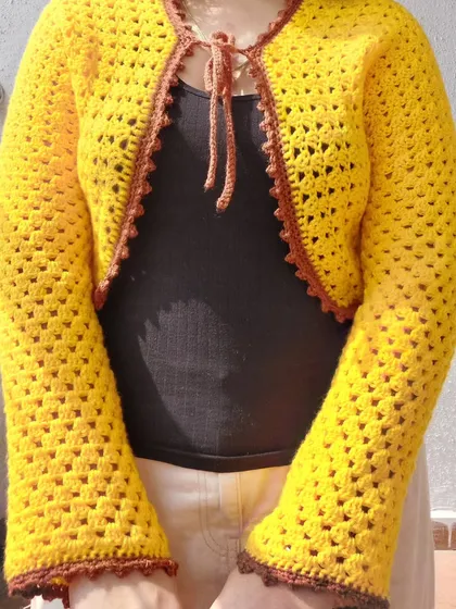 A close-up of the front of the Odette Cardigan, highlighting the tie closure and granny stitch texture.