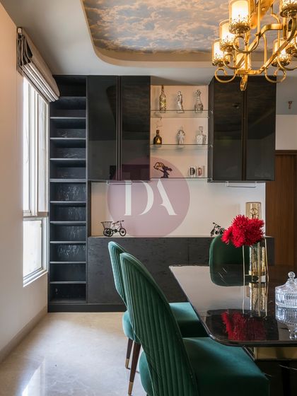 Functionality is key in this dining area, which features a custom-built bar and crockery unit. The dark, glossy finish and glass shelves provide a sleek storage solution that is both practical and stylish for entertaining.