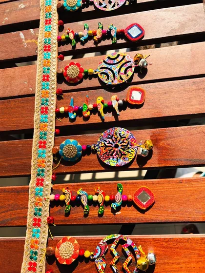 The intricate patterns of the 'Rang-Tarang' toran, with its mix of ceramic beads, wooden birds, and my psychedelic art prints.
