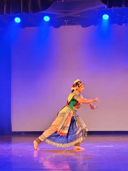 A dynamic pose from a Thillana performance. The Thillana is a pure dance piece, characterized by its complex rhythms, fast-paced movements, and sculptural poses.