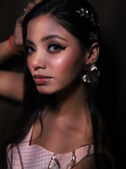 A powerful pose from our glam look shoot. The lighting and makeup come together to create a dramatic and high-fashion feel.