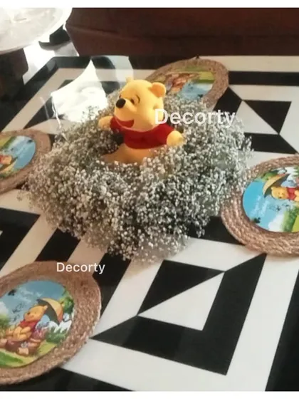The Winnie the Pooh centerpiece on a modern black and white table, surrounded by themed placemats.