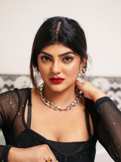 A bold and direct portrait of model Mandira Sweety. The red lipstick and chunky silver necklace create a strong focal point in this close-up beauty shot.