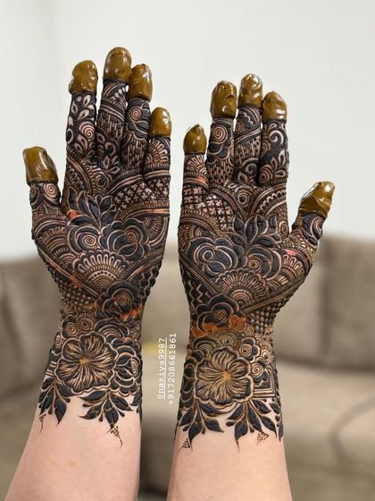 Symmetrical floral designs on both hands, with dark-tipped fingers for a classic bridal feel.