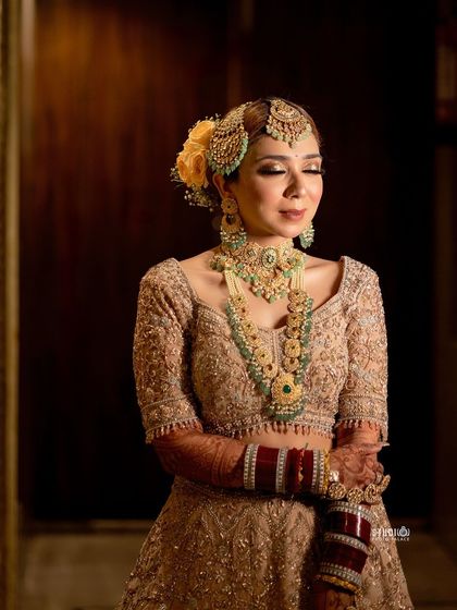 A serene and graceful pose from my wedding day. The soft-focus lighting highlights the flawless airbrush makeup finish and the intricate details of my bridal jewelry and hair.