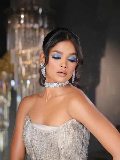 A full view of the glamour. The bright blue on the eyes provides a stunning contrast against the silver beaded gown.