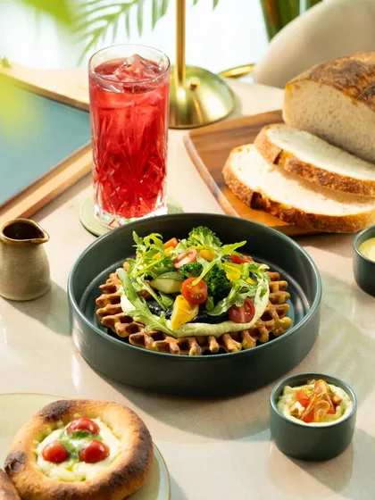 A savory waffle topped with fresh greens and vegetables. This is a great way to showcase a healthier, lighter brunch option.