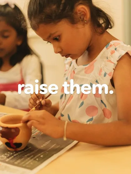 A young artist carefully paints a clay pot. We provide opportunities for children to work with various media, from paper and paint to pottery.
