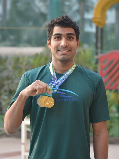 Aaryan Bhosale showcasing his medals from the Individual Championship, including two relay golds and a silver in the 100m Freestyle.