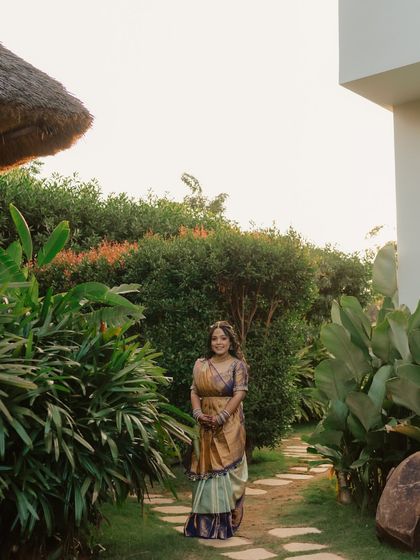A serene portrait of the bride in a lush garden during her pre-wedding shoot. Her traditional South Indian sari and the natural surroundings create a beautiful and peaceful image.