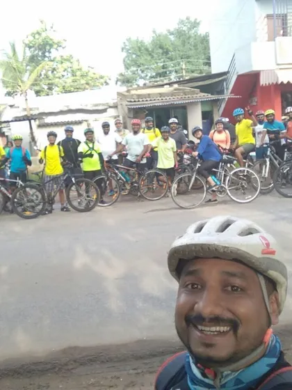 A big group selfie with a wide smile from the ride leader, capturing the energy of the whole team.
