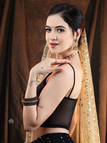 A close-up portrait from the Indo-western series, highlighting the model's soft expression and the delicate gold-dotted dupatta. The warm lighting creates an inviting and gentle mood.