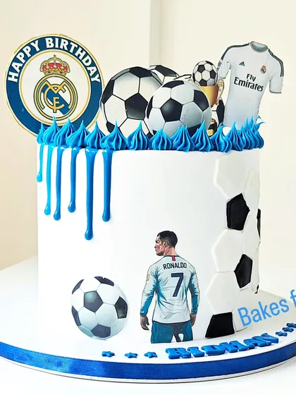 A Real Madrid-themed football cake featuring Cristiano Ronaldo. The blue drip and team logo make this a perfect choice for a fan of the club.