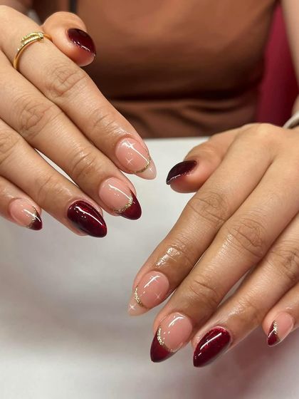 A deep red French tip with a thin gold glitter line. This small detail adds a lot of elegance to the design.