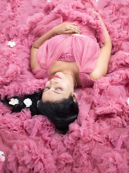 A dreamy overhead shot with the mom-to-be nestled in a cloud of pink ruffled fabric. This is such a beautiful and artistic way to capture a serene maternity moment.