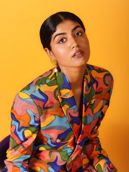 A classic beauty shot with a direct, engaging gaze. The vibrant colors of the jacket frame her face perfectly.