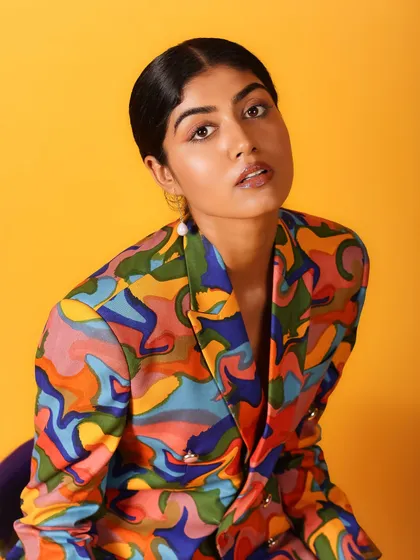 A classic beauty shot with a direct, engaging gaze. The vibrant colors of the jacket frame her face perfectly.