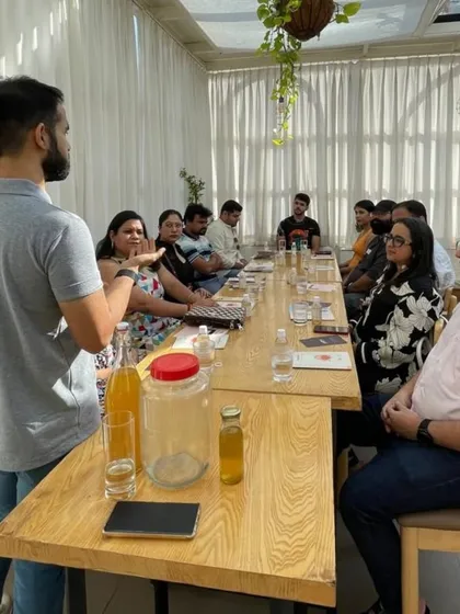 A group of participants listens as our expert explains the science behind fermentation. You can see the starter cultures and bottles on the table, ready for the hands-on portion of the workshop.