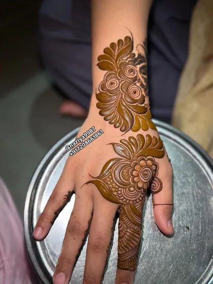 This design combines a wrist motif with a matching pattern on the finger. It's a stylish way to wear henna without full coverage.