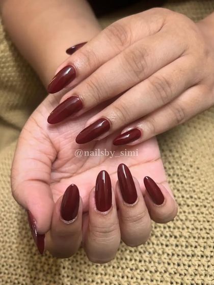 Natural nails supremacy! A gorgeous deep red polish on long, natural almond-shaped nails.