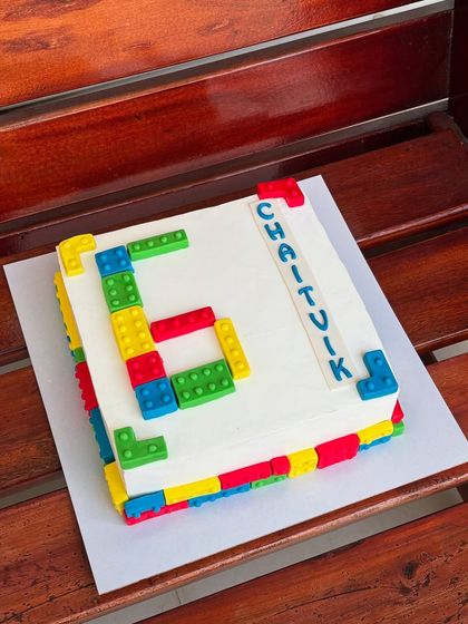 A Lego-themed sheet cake, perfect for a young builder's birthday. The design features edible Lego blocks forming the number six.