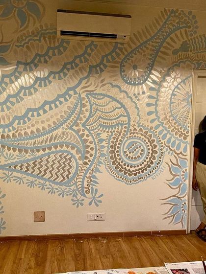 Me with the 'Subtle Charm of Delhi' mural. This project shows that my abstract and ethnic patterns can also be rendered in a soft, calming palette for a completely different effect.