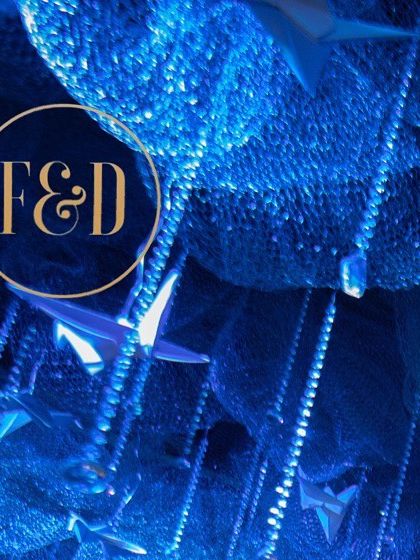 A close-up detail of the winter wonderland ceiling. Paper origami birds and crystal beads hang from a blue mesh, creating a beautiful texture and a sense of movement.