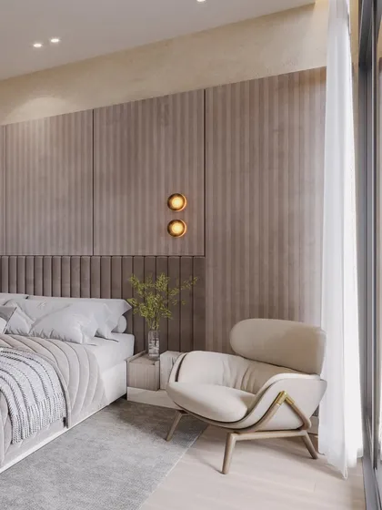 This close-up highlights the layered textures of the headboard and wall panels, along with the soft glow of the wall sconces.