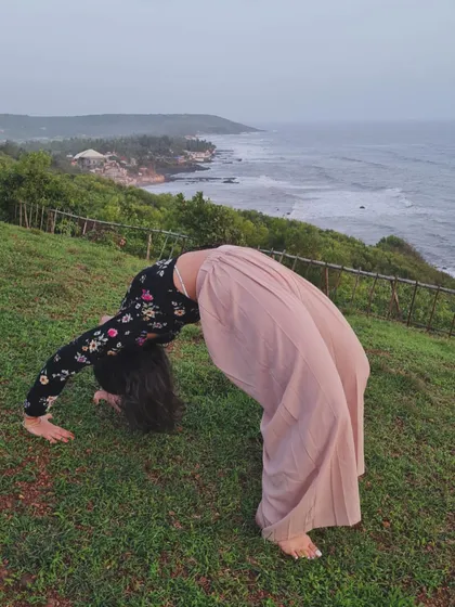 Moving into Chakrasana, or Wheel Pose, on a grassy cliff overlooking the ocean. This deep backbend is incredibly energizing and opens up the heart center.