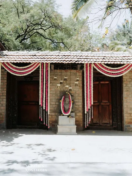 An entranceway adorned with garlands of white and red flowers, a classic and welcoming decor element for any Indian celebration.