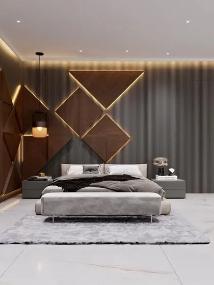 A wide view of a spacious and modern master bedroom. The design incorporates a geometric, backlit headboard wall, a separate seating area, and a consistent color palette of grey, wood, and white for a cohesive and luxurious feel.